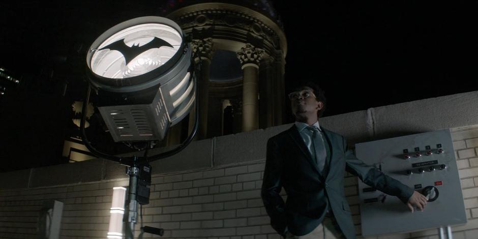 Luke flips the switch to turn on the new Bat-Signal with Batwoman's logo.