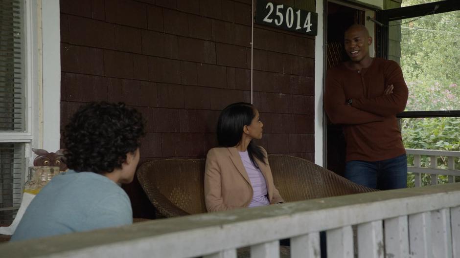 Kelly looks up at James who is leaning against the door as he tells Simon Kirby that he found a lawyer to help her mother.