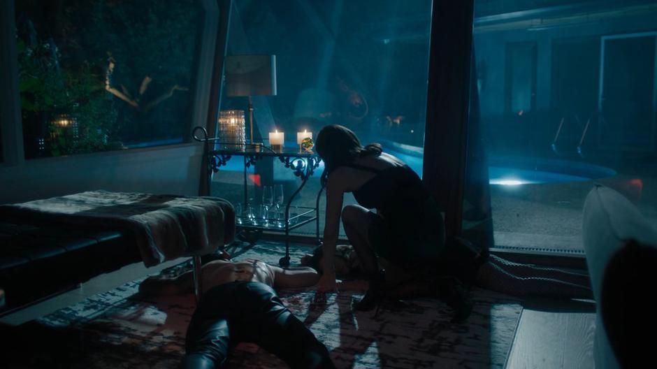 Abigael kneels down over her two dead companions.