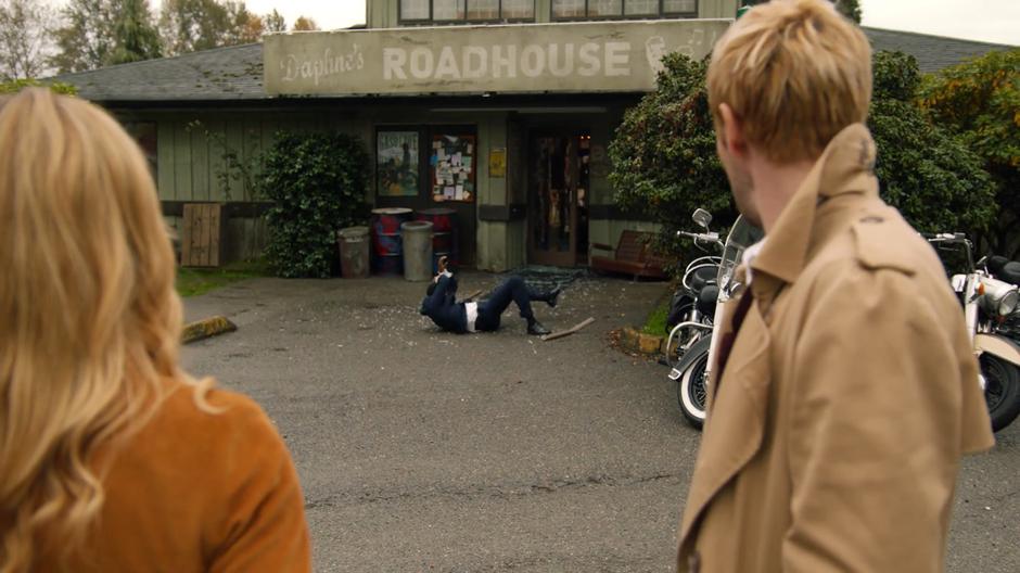 Sara and Constantine watch as a Time Bureau agent is thrown from the roadhouse in a crash of glass.