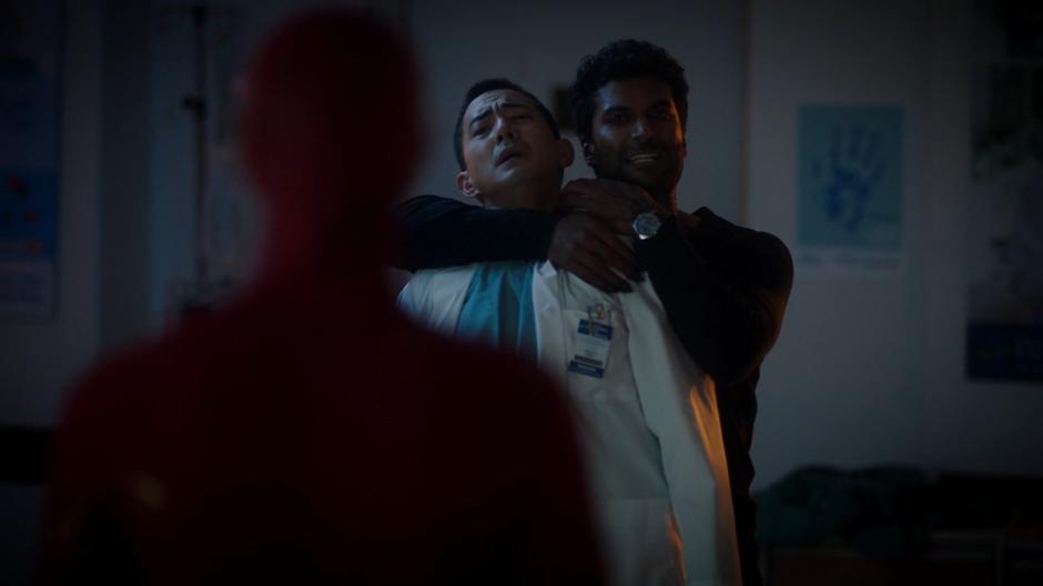 Ramsey holds Dr. Rodrigo by the neck and threatens him while facing off against Barry.