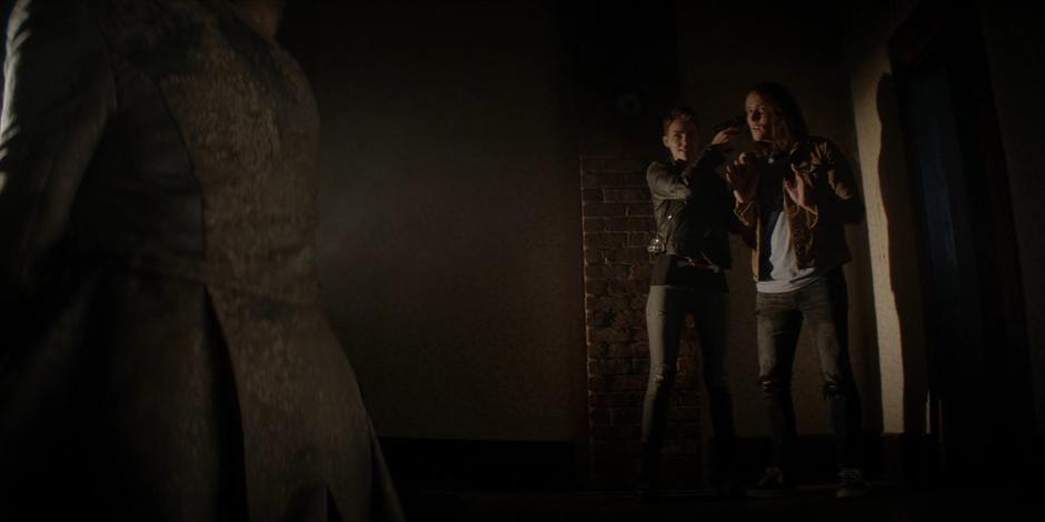 Kate holds her gun on Mouse and tries to get Alice to release their father.