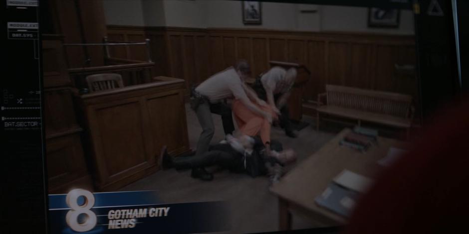 Two baliffs pull Chris Metlock off of Angus Stanton at the front of the courtroom in archival news footage.