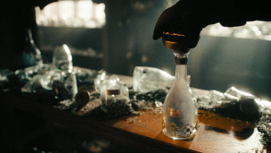 A mysterious figure unlocks the bottle holding the essence of Harry's Darklighter.