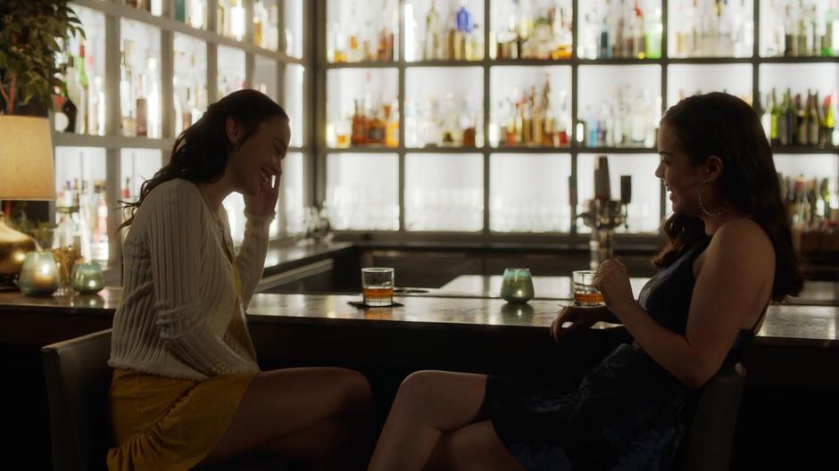 Young Lena and Andrea laugh over drinks at the bar.