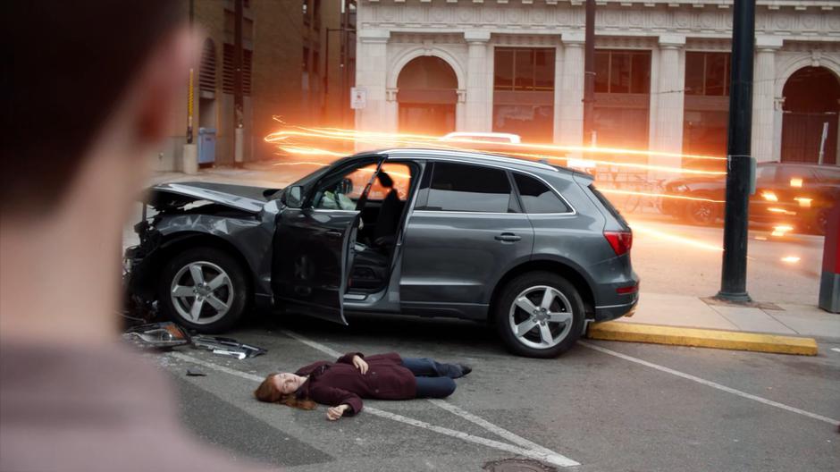 Barry watches as a vision of his future self zips in to where a woman is lying dead on the ground after a car accident.