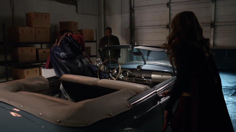 J'onn talks to Kara as she gets into his space car with that guy.