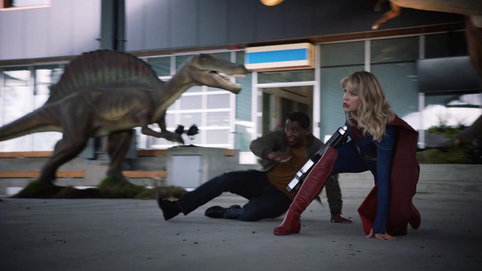 J'onn and Kara fall to the ground as the Earth shakes.