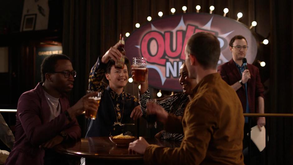 The winning quiz team toasts after the host announces the final answer.