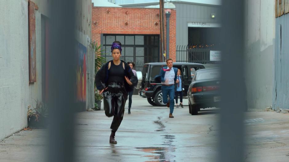Xavin races down the alley chased by the Daughter and the Magistrate.