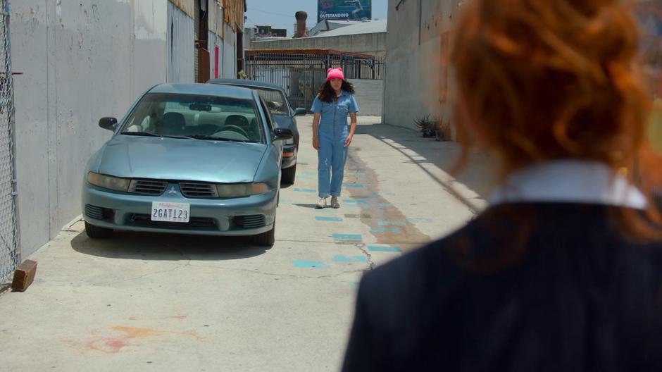 Molly emerges from behind a car and approaches the Wife in Stacey's body.
