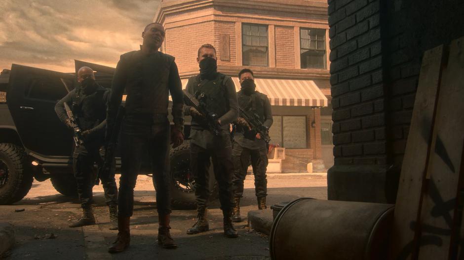 AWOL stands at the end of the alley with three goons at his back.