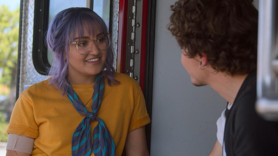 Gert smiles at Max while they chat at the back of the ambulance.