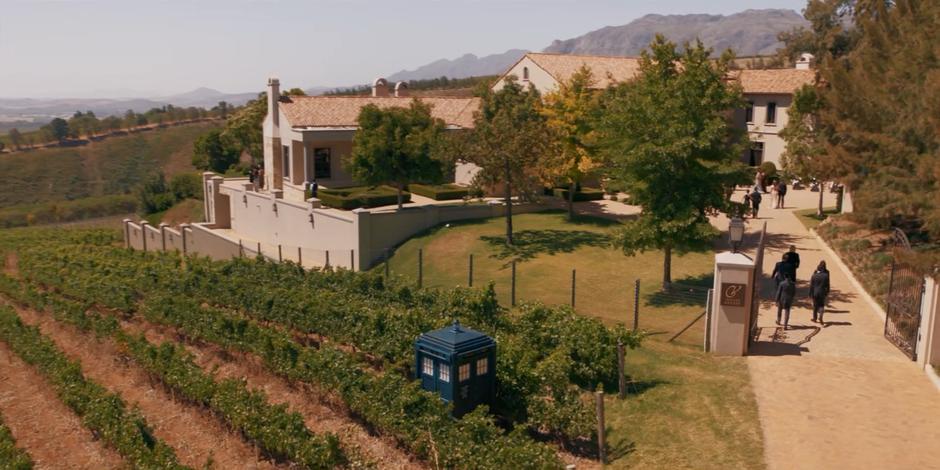 The gang walks through the gate towards the state as the TARDIS sits among the vines.