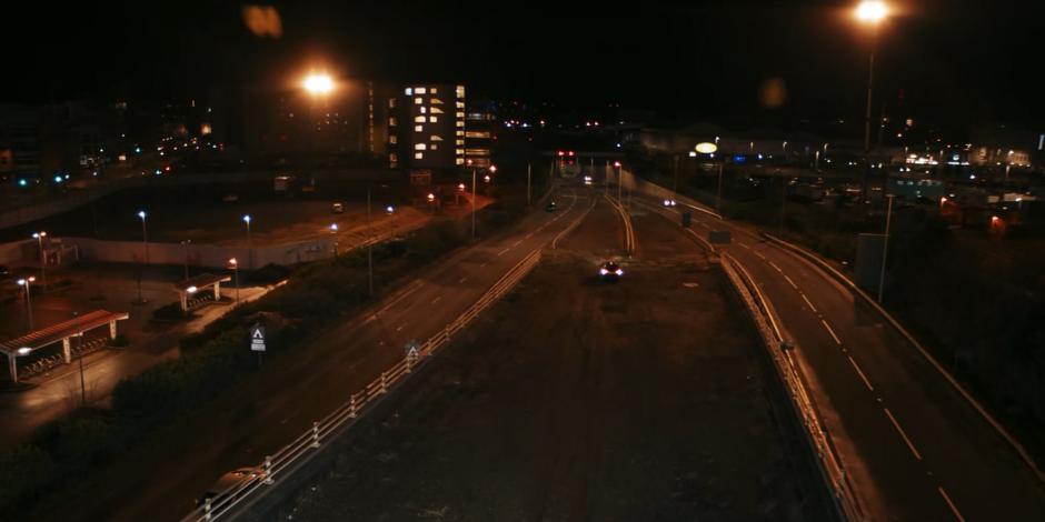 The government vehicle emerges from the tunnel and backs onto an elevated construction at high speed.