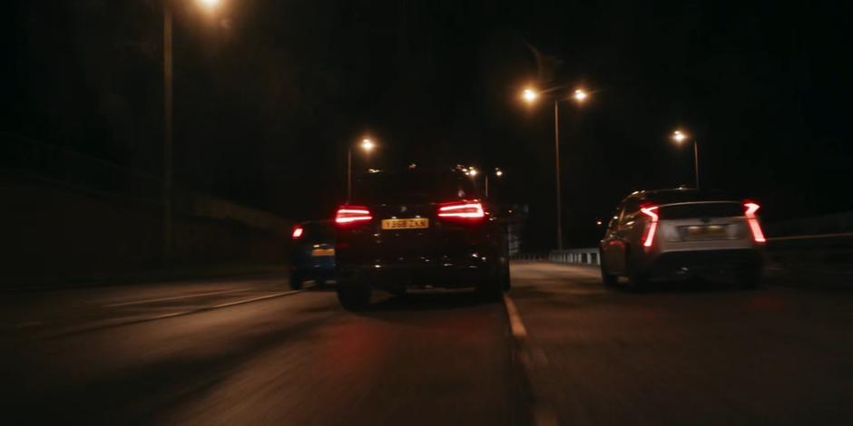 The government vehicle drives on its own between two other cars.