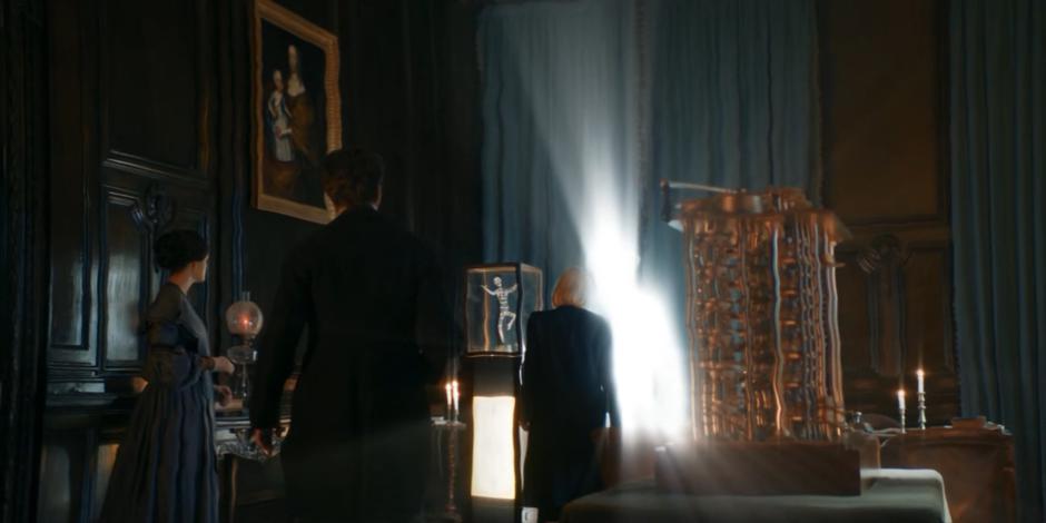 Ada and Babbage watch as the Doctor approaches the figure of light she summoned.
