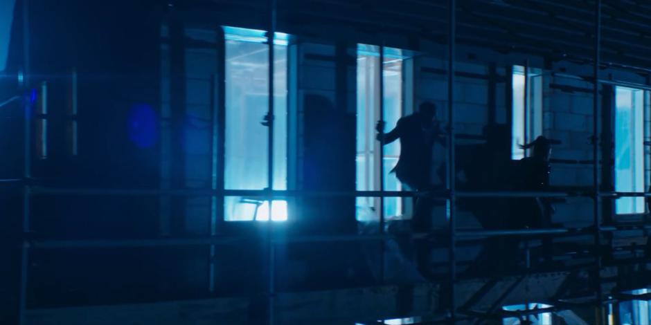 Ryan, Graha, and Yaz jump out the window and run along the scaffolding as the figures of light pursue them from inside.