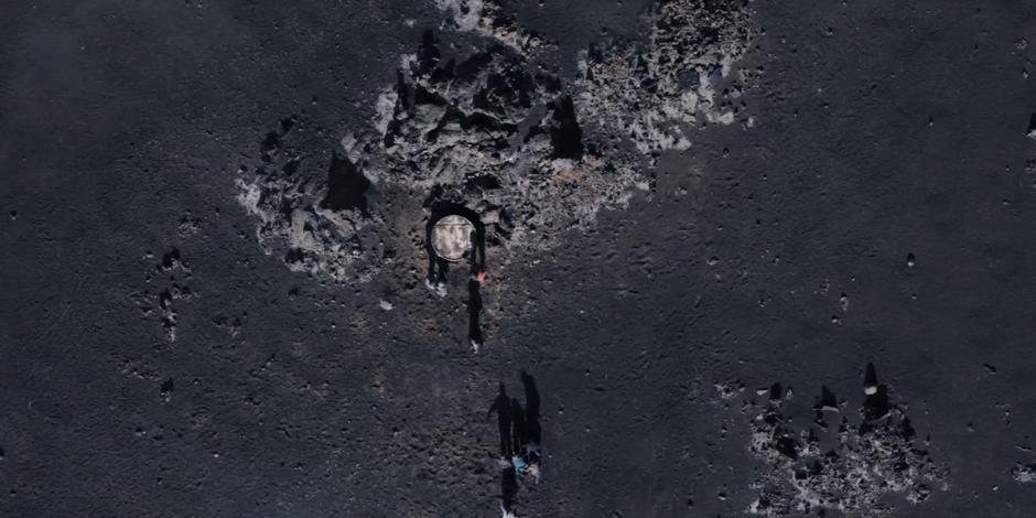 The group runs up to the access shaft in the desolate landscape.