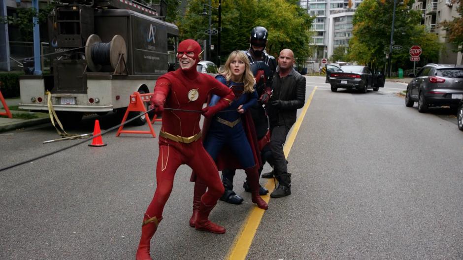 Barry, Kara, Ray, and Mick pull the cord to trip Beebo.