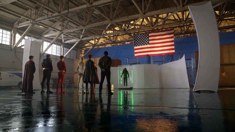 Clark, Jefferson, Barry, Sara, Kate, and J'onn watch as Kara steps up to the memorial to say some words about Oliver.