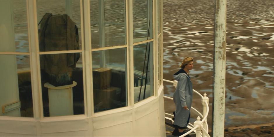 The Doctor stands on the outside of the tower and looks out around the landscape.