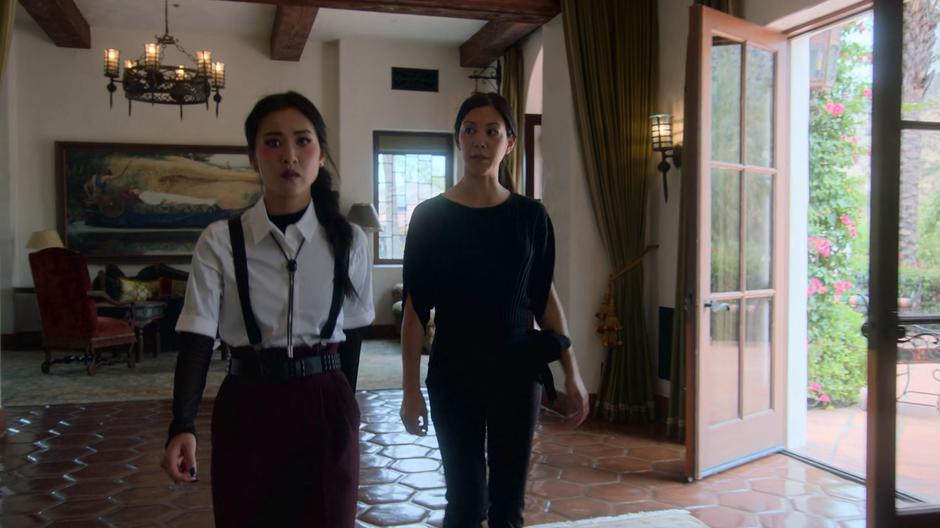 Tina glances as Nico as she leads them through the hotel.