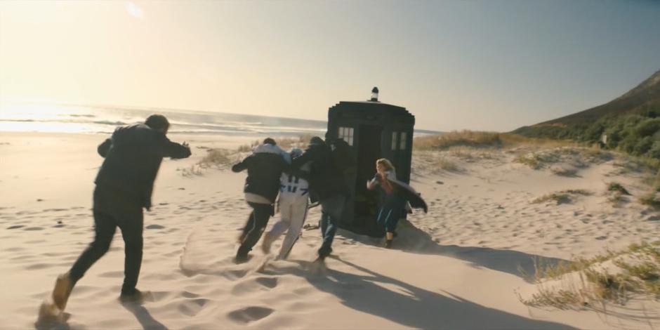 The Doctor motions for the group to run into the TARDIS.