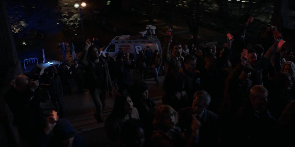 Protestors walk up the steps of the police headquarters in support of Batwoman.