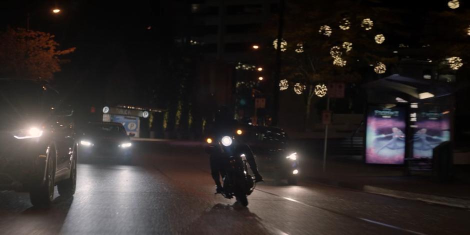 Kate weaves her way through traffic on her motorcycle.