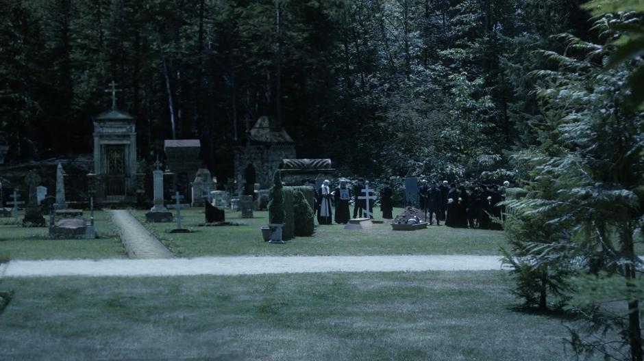 Mourners surround Rasputin's coffin in the distance.