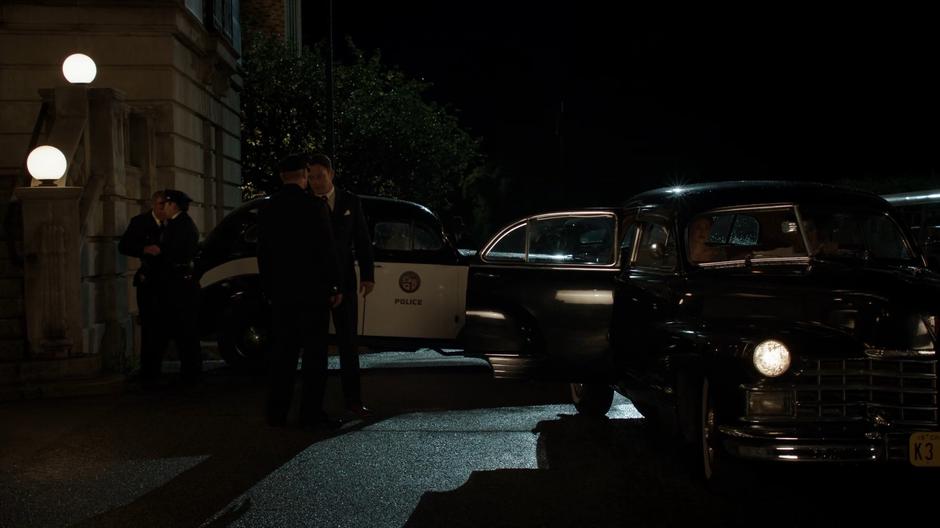 The police chief talks to Bugsy while Jeanie Hill waits in the car with Constantine.