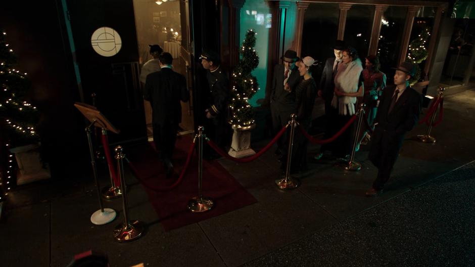 People line up behind the velvet rope to get into the club.