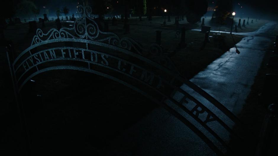 Establishing shot of the cemetery gate at night.