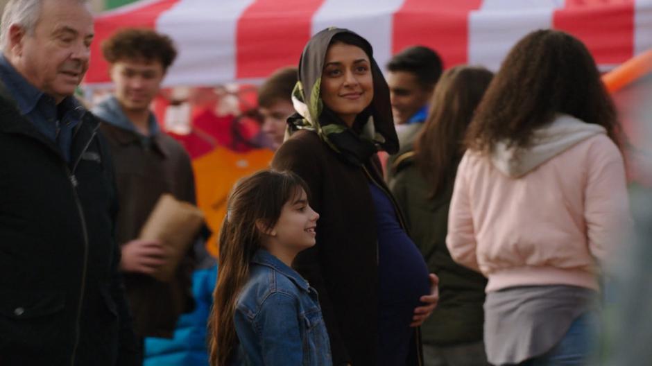 Young Zari and her pregnant mother Nasreen walk through the crowds at the park.