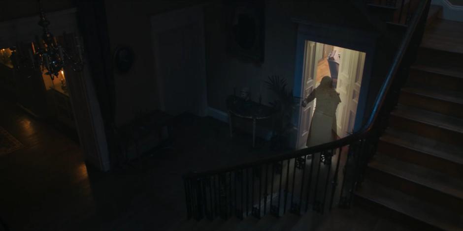 A ghostly figure appears in the door at the bottom of the stairs.