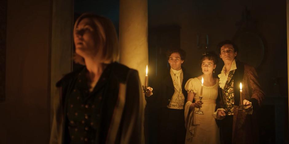 John, Claire, and Byron follow the Doctor with candles as she head to the front door.