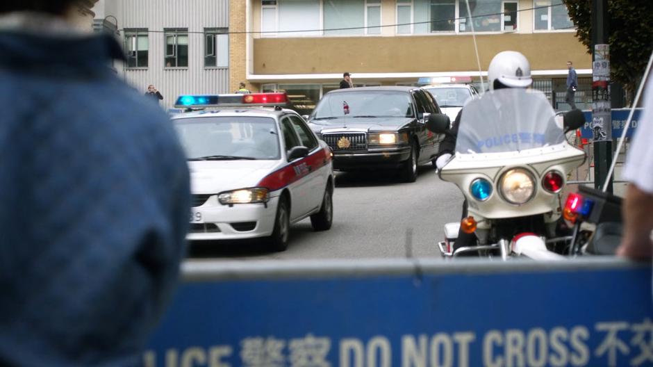 Prince Charles's motorcade drives down the street past the intersection.