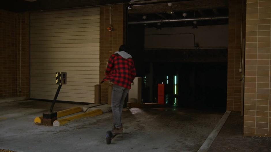 Behrad rides his stolen scooter into the parking garage.