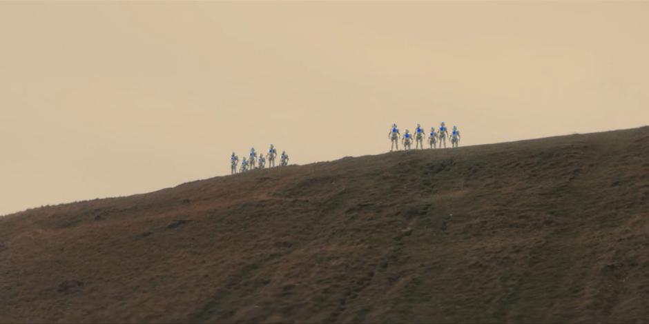 A dozen Cybermen appear on the hill high above the bay.
