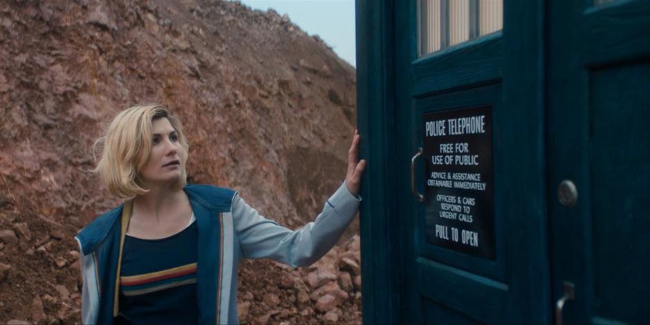 The Doctor puts her hand on her TARDIS before going back inside.