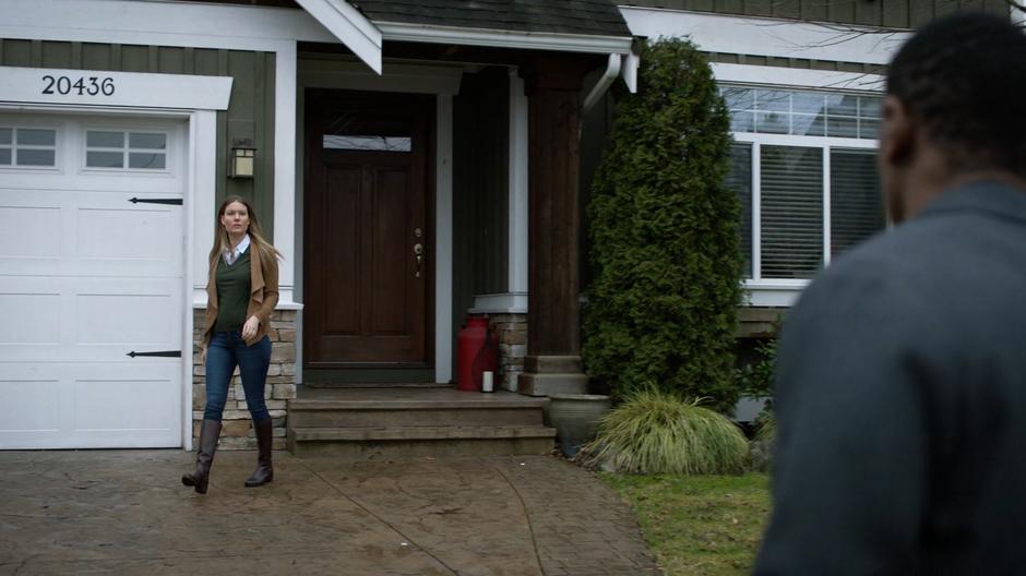 Jennifer Bates turns whe J'onn approaches her as she is leaving her house.
