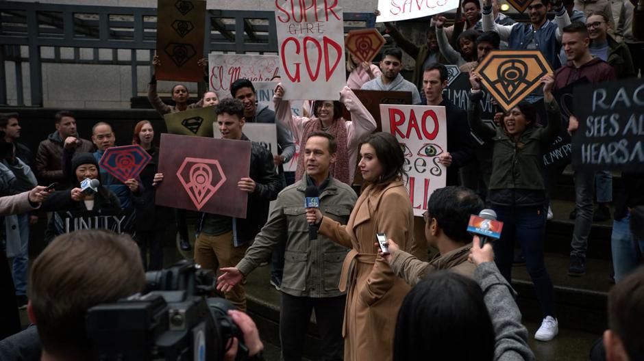 Thomas Coville talks to a reporter in front of a group of cheering members of the Cult of Rao.