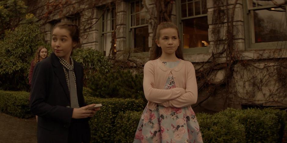 Young Kate and Beth stand outside after their Bar Mitzvah and watch their father load presents into the car.