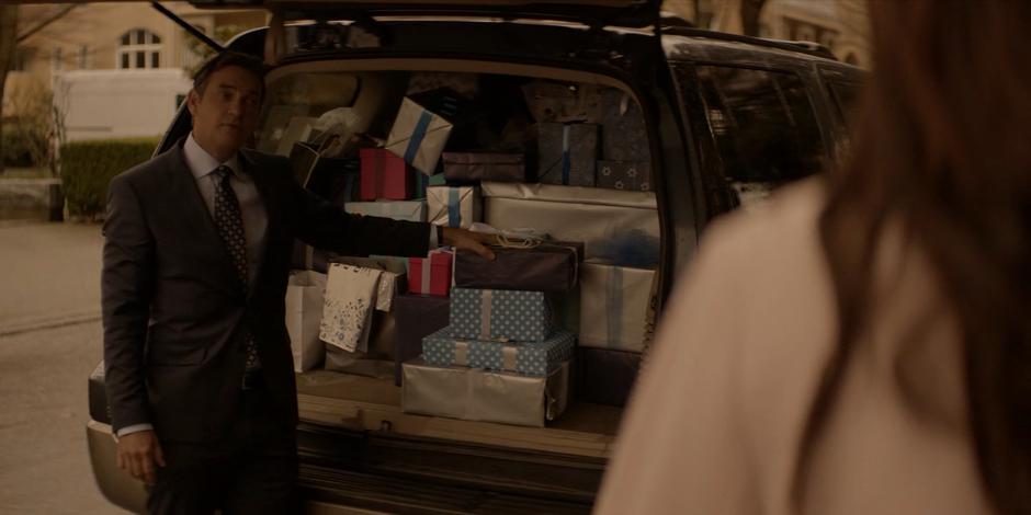 Jacob turns back to his family after putting the last of the gifts into the back of the car.