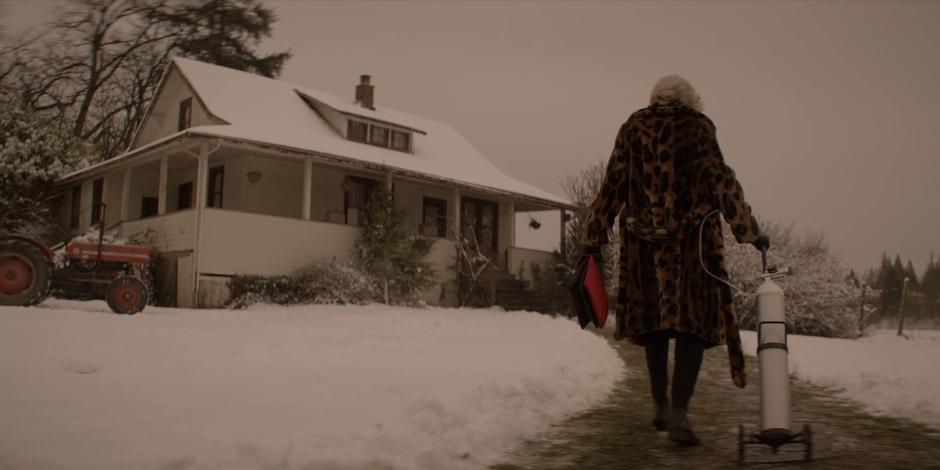 Mabel Cartwright wheels her oxygen tank down the path to the front of the house.