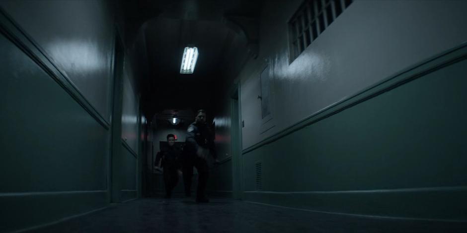 Two guards run towards Kate when they see her in the hallway.