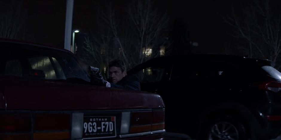 Jacob pops up over the trunk of a car to fire at the sniper.