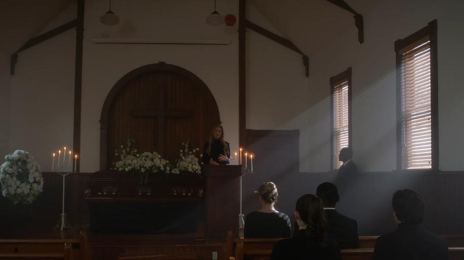 Eliza gives the eulogy at the front of the church.