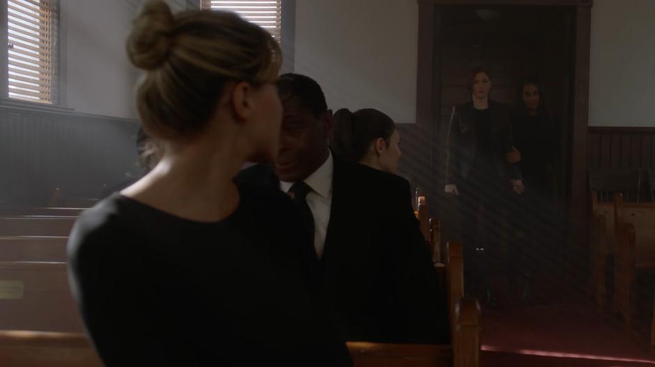Kara turns and watches as Alex enters with Kelly.